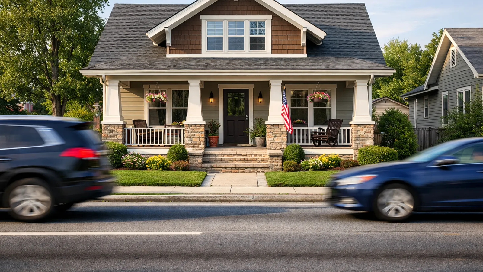 A suburban home with a small front yard directly exposed to passing cars and pedestrians on a busy street.