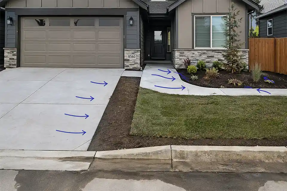 Front yard after regrading and new hardscaping with runoff directed toward the house and planting bed